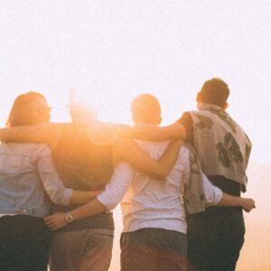 The backs of four people arms interlocked behind them