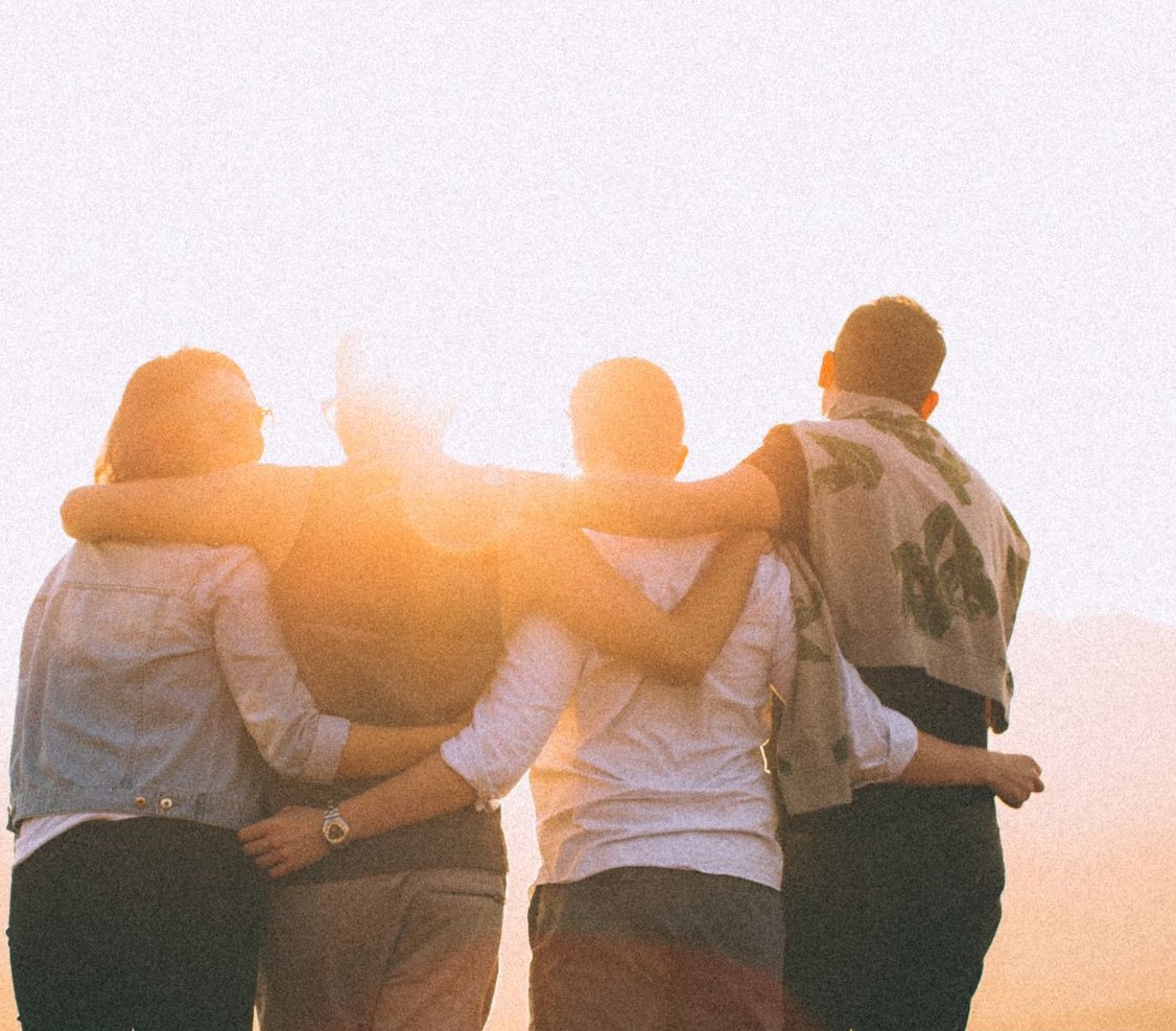 2026-10-31-how-to-stay-kind-when-others-arent The backs of four people arms interlocked behind them