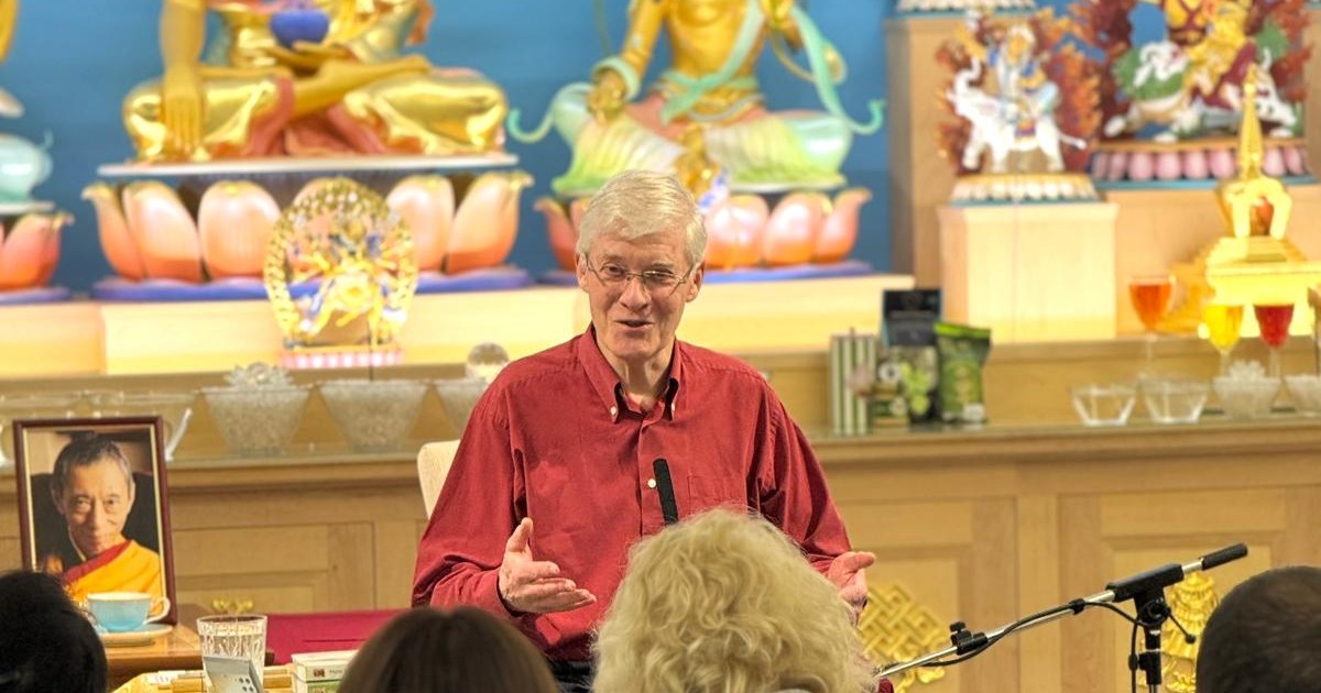 Kadam John McBretney teaching a class in the Heruka KMC meditation hall, with a photo of Geshe Kelsang Gyatso beside him